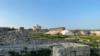 Остатки стен древнего Херсонеса, на заднем плане видны современные сооружения для культурно-развлекательных мероприятий, март 2021 года