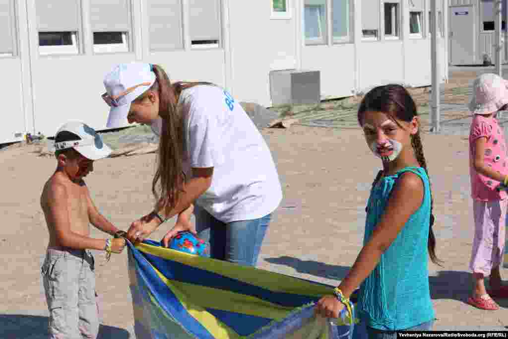 Вправа на командну гру. Одній із команд кладуть м&rsquo;яча на тканину, і вона має перекинути його на простирадло іншої групи гравців