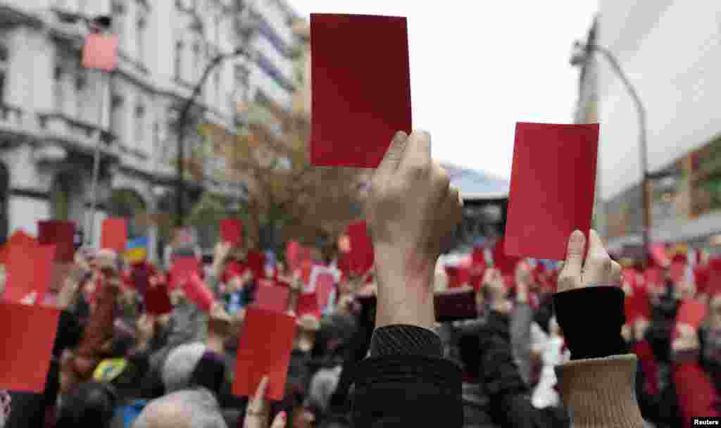 Demonstrators show symbolic red cards to Czech President Milos Zeman during a protest rally in Prague on November 17.