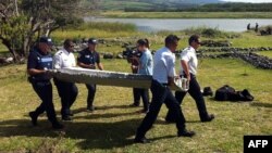 پلیس در حال حمل قطعه‌ای که پیدا شده است