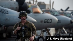 Ethan Tews tűzszerész sétál az Arab-tengeren állomásozó USS Ronald Reagan repülőgép-hordozó fedélzetén 2021. július 30-án.
