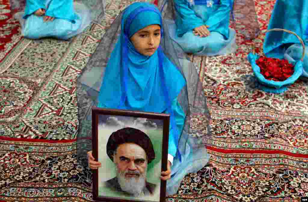 An Iranian girl holds a picture of the late supreme leader Grand Ayatollah Ruhollah Khomeini at the Khomeini shrine in Tehran. Iranians on February 1 marked the 36th anniversary of Khomeini's return from exile in Paris to Iran. (epa)