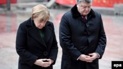 German Chancellor Angela Merkel (left) and Ukrainian President Petro Poroshenko pause for a moment at the site of the Christmas market terrorist attack at Breidscheidplatz in Berlin on January 30.