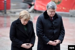 Ukrainian President Petro Poroshenko (right) cut short a visit with German Chancellor Angela Merkel to deal with the crisis in the east.