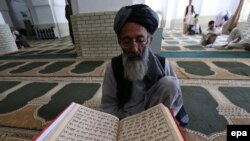 An elderly Afghan reads the Koran at the beginning of Ramadan in the western Afghan city of Herat.
