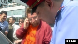 Полицейский оформляет протокол задержания журналиста Андрея Свиридова. Алматы, 16 сентября 2009 года.