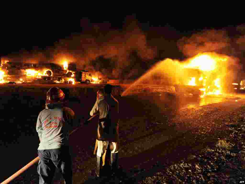 Firefighters try to extinguish burning NATO supply trucks carrying military vehicles and oil after militants attack on the outskirts of Islamabad in June 2010.