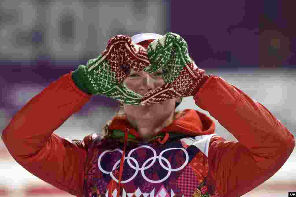 Gold-medalist Darya Domracheva of Belarus makes the shape of a heart with her hands as she celebrates on the podium in the women&#39;s 12.5-kilometer mass-start biathlon. (AFP/Odd Andersen)