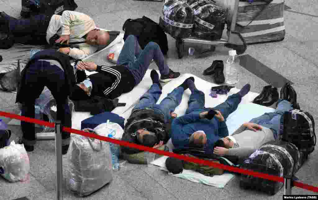 Stranded travelers sleep on sheets at Vnukovo International Airport near Moscow on March 27, the first day the international flight ban ordered by the Russian government&nbsp;
