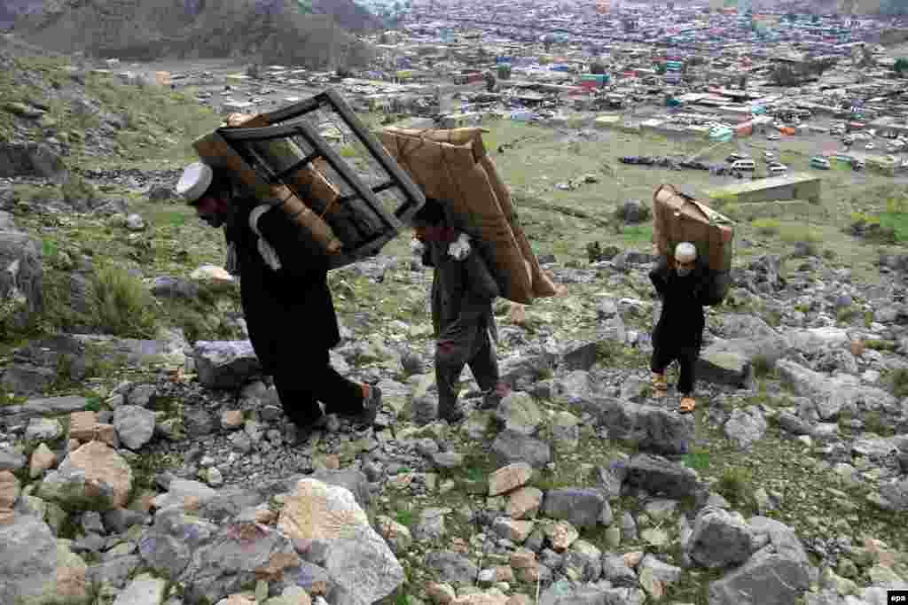 Afghan boys carry foreign-made spare car parts as they cross into Pakistan through the rugged mountainous Toorkham border crossing. (epa/Ghulamullah Habibi)
