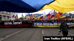 Ukrainian and Russian flags fly at a protest in Moscow against Russia's takeover of Crimea on March 15, 2014.