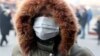 A person wears a protective mask on the street as a dirty winter smog blankets Sarajevo. (file photo)