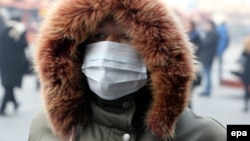 A person wears a protective mask on the street as a dirty winter smog blankets Sarajevo. (file photo)