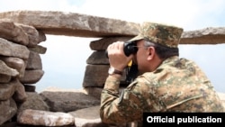 Armenia - Defense Minister Seyran Ohanian looks through binoculars at Azerbaijani army positions on the border with Armenia, 24Jul2013.