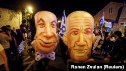 Demonstranti s maskama premijera Benjamina Netanjahua i ministra odbrane Benija Ganca na protestu u Jerusalimu, 8. avgust 2020.