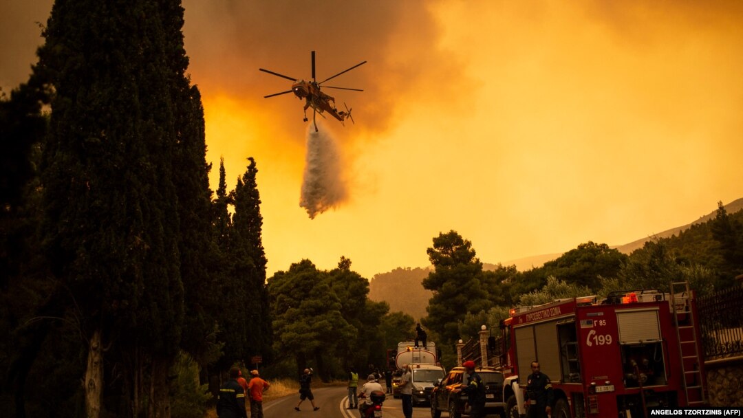 Helikopter izbacuje vodu na šumske požare u selu Vila, severozapadno od glavnog grada Grčke, Atine, 18. avgust 2021. 