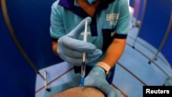 Një punëtor shëndetësor në Spanjë duke administruar një dozë të vaksinës kundër koronavirusit. 