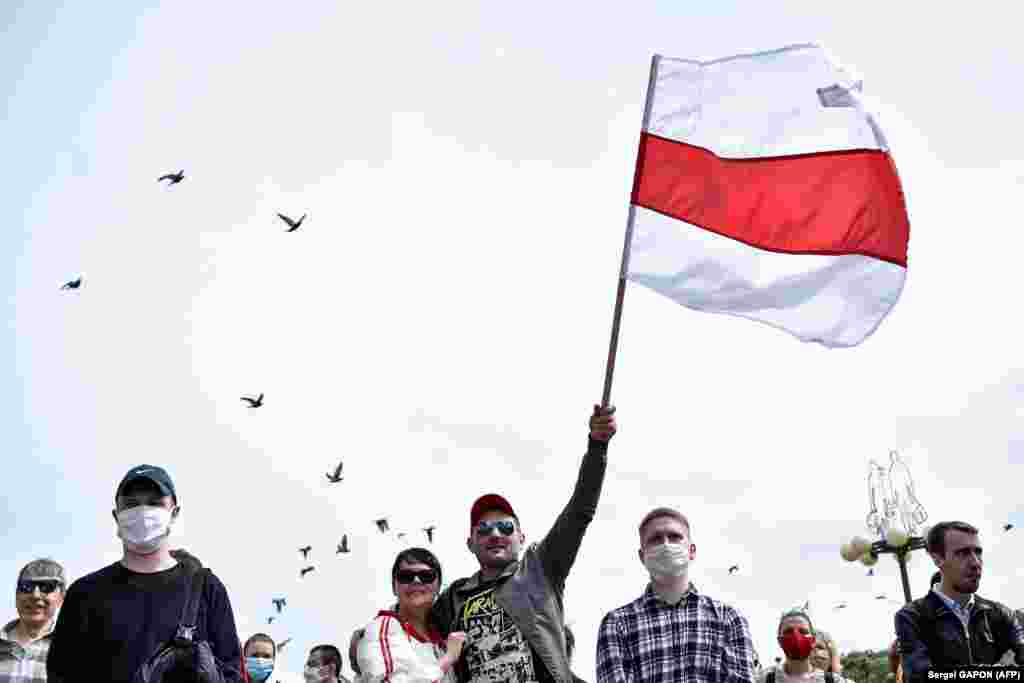A protester waves the old Belarusian flag in Minsk during the collection of signatures. &nbsp;