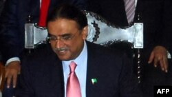 Pakistan's President Asif Ali Zardari signs a constitutional reform law during a ceremony in Islamabad.