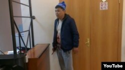 Жезқазған сотында қарнын тілді адам. Журналист Андрей Цукановтың интернетте жариялаған видеосынан скриншот. 17 мамыр 2017 жыл.