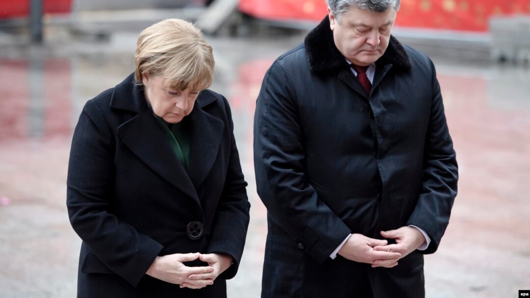 German Chancellor Angela Merkel (left) and Ukrainian President Petro Poroshenko pause for a moment at the site of the Christmas market terrorist attack at Breidscheidplatz in Berlin on January 30.