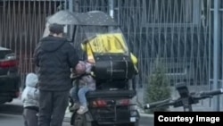 Балдары менен курьерлик кылган келин. Соцтармактардагы видеодон алынган сүрөт.  Бишкек. Октябрь, 2026-жыл.