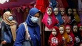 INDONESIA-HIJAB/RIGHTS/Women walk past hijabs displayed for sale at the Tanah Abang textile market in Jakarta, Indonesia, March 16, 2021.