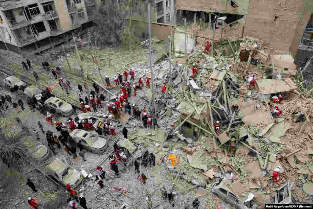 Rescuers on March 16 work at the site of a strike that destroyed a building in Tehran. 