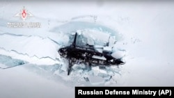 A Russian nuclear submarine breaks through the Arctic ice during military drills at an unspecified location in the Arctic on March 26.