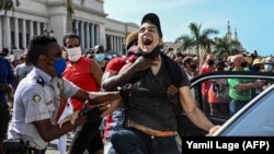 Кубинские полицейские задерживают участника протестов в Гаване 