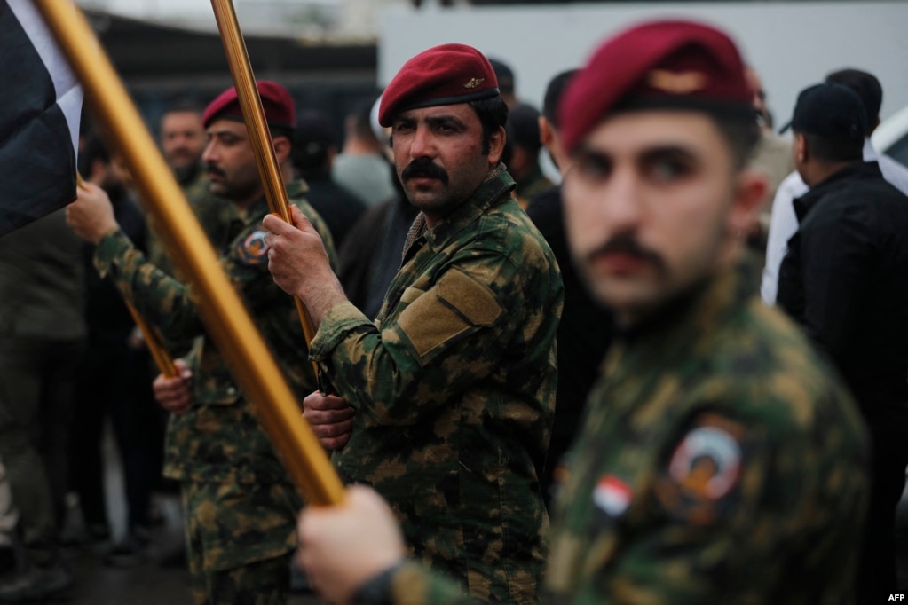 Các thành viên của Lực lượng Huy động Nhân dân Iraq (PMF) tham dự lễ tang tập thể ở Baghdad vào ngày 24 tháng 3, dành cho Saad Dawai, chỉ huy PMF của tỉnh Al-Anbar ở miền tây Iraq, một khu vực an ninh trọng yếu giáp với Syria, Jordan và Ả Rập Xê Út.
