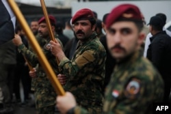 Members of Iraq’s Popular Mobilization Forces (PMF) attend the mass funeral in Baghdad on March 24, for Saad Dawai, the PMF commander for Al-Anbar Province in western Iraq, a key security region bordering Syria, Jordan, and Saudi Arabia.