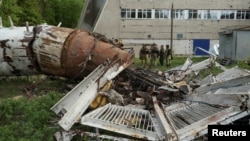 Ukrainian police officers stand next to part of a television tower that was partially destroyed by a Russian missile strike in Kharkiv on April 22. 