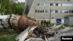 Поліцейські стоять біля частини телевізійної вежі, частково зруйнованої російським ракетним ударом у Харкові, Україна, 22 квітня 2024 року