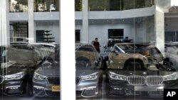 In this Sept. 17, 2018 file photo, imported cars are displayed at a showroom in Tehran, Iran. With high customs duties, these luxury cars cost 2-3 times more in Iran than in most other countries.