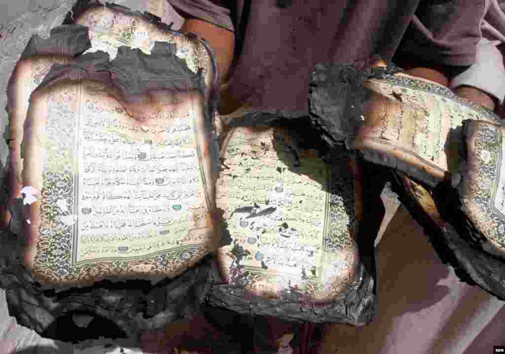 An Iraqi man displays a Koran destroyed during fighting with insurgent militias in Baghdad in July (epa) - During an interview with RFE/RL's Radio Free Iraq in April, former Iraqi Prime Minister Iyad Allawi warned of the beginning of a "social split" in Iraq that, if unchecked, could lead to "catastrophe."