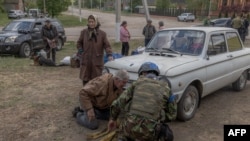 Tetjana, 75, evakuisana iz grada Vovčanska, stoji pored automobila u kojem su ona i njen suprug pobjegli. 12. maja stigli su na evakuacioni punkt u oblasti Harkiv.