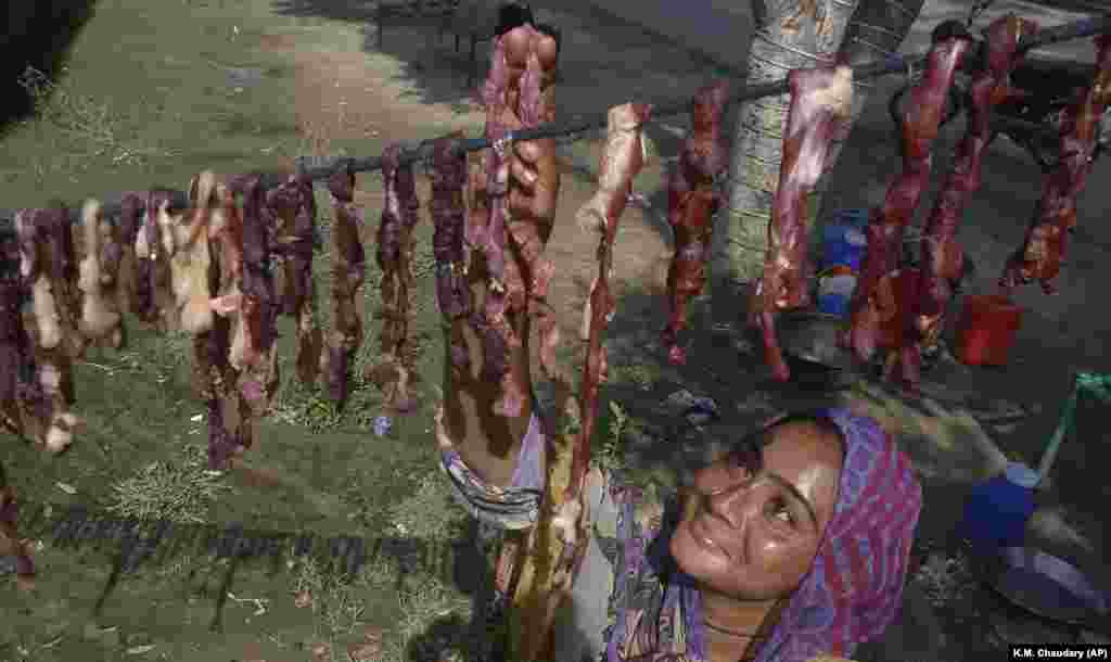 A woman hangs strips of salted meat during the Islamic Eid al-Adha, or Festival of Sacrifice, in Lahore, Pakistan. (AP/K.M. Chaudary)