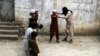 An unidentified militant of Islamic State (IS) imparting light weapons training to children at an undisclosed location in the Kunar province, eastern Afghanistan in July.