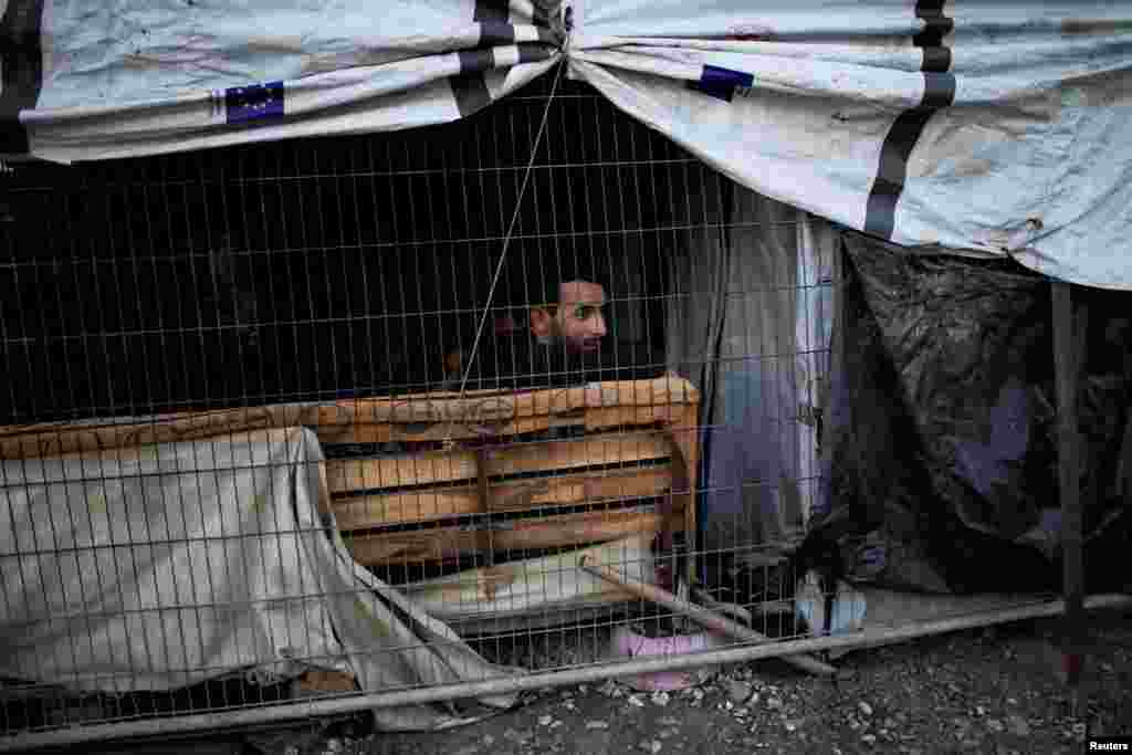 Një migrant është parë brenda tendës së tij, në një kamp të improvizuar pranë kampit Moria.&nbsp;
