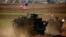 A convoy of U.S. armored vehicles drives on the western outskirts of the northern Syrian city of Manbij. (file photo)