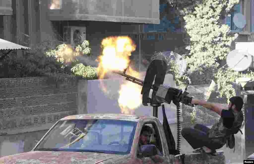 A member of the rebel Free Syrian Army opens fire with his machine gun during clashes with Syrian Army forces in Aleppo on September 27. (REUTERS/Zain Karam)