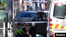 Police sit in front of a crashed vehicle after Saeed Noori, the driver, was arrested after plowing into pedestrians at a crowded intersection in Melbourne in December 2017.