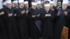 The grand mufti of Bosnian Muslims, Mustafa Ceric (right), and others pray at the grave of General Rasim Delic in Sarajevo.