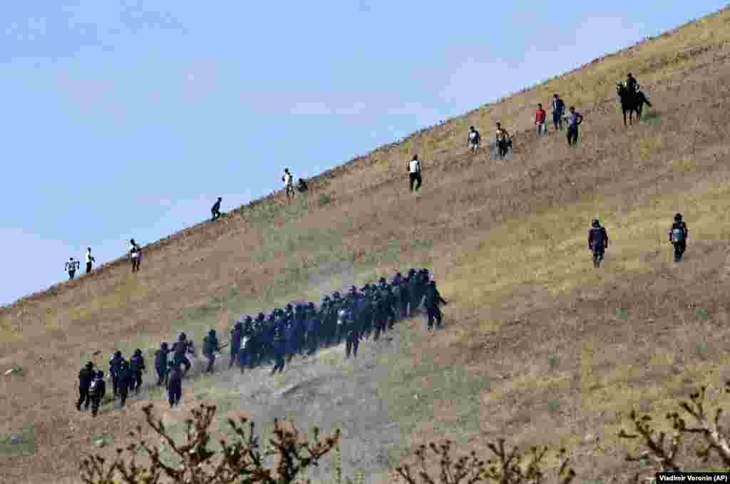 Kyrgyz riot police pursue supporters of former President Almazbek Atambaev near his residence in the village of Koi-Tash, about 20 kilometers south of Bishkek. Police in Kyrgyzstan detained Atambaev following violent clashes with his supporters. He is being charged with corruption. (AP/Vladimir Voronin)