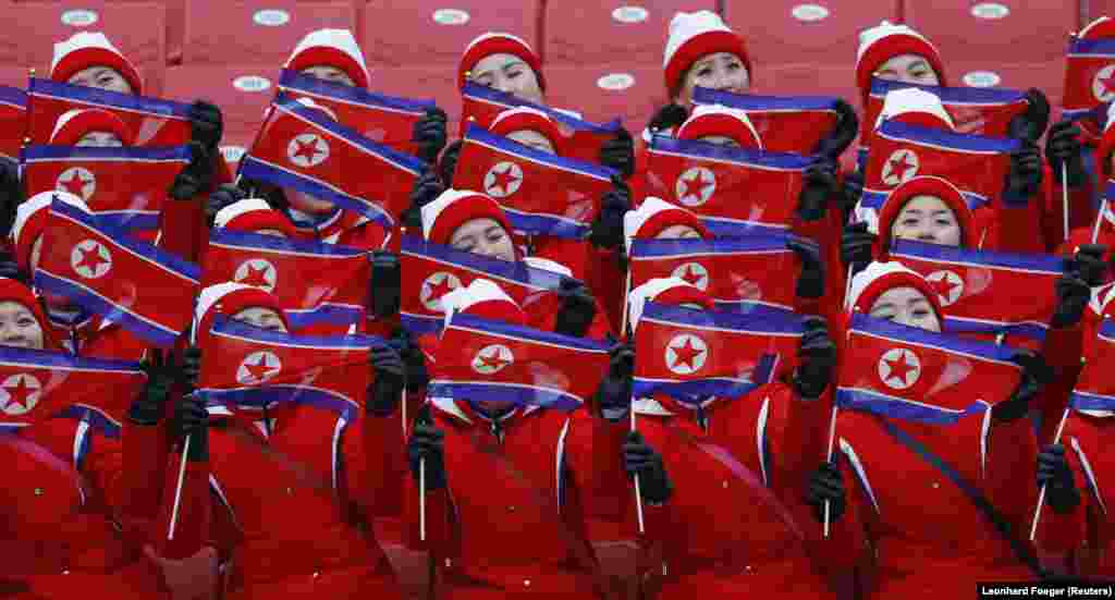 Девушки держат флаги Северной Кореи на соревнованиях по горнолыжному спорту среди женщин в слаломе. 14 февраля 2018 года.