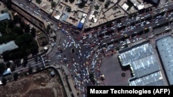 Люди и автомобили, скопившиеся перед входом в аэропорт Кабула, на снимке со спутника, 23 августа 2021 года