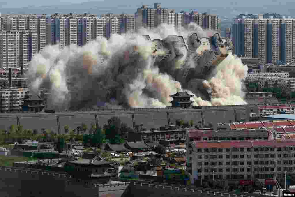 A building crumbles during a controlled demolition conducted to better protect the nearby ancient area of the city in Datong in Shanxi Province, China. (Reuters)