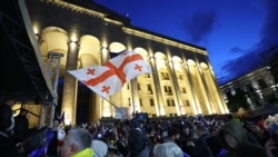 A protester waves the flag of Georgia during a rally against the controversial "foreign agent" bill in Tbilisi on May 14.