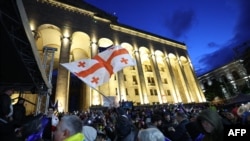 A protester waves the flag of Georgia during a rally against the controversial "foreign agent" bill in Tbilisi on May 14.
